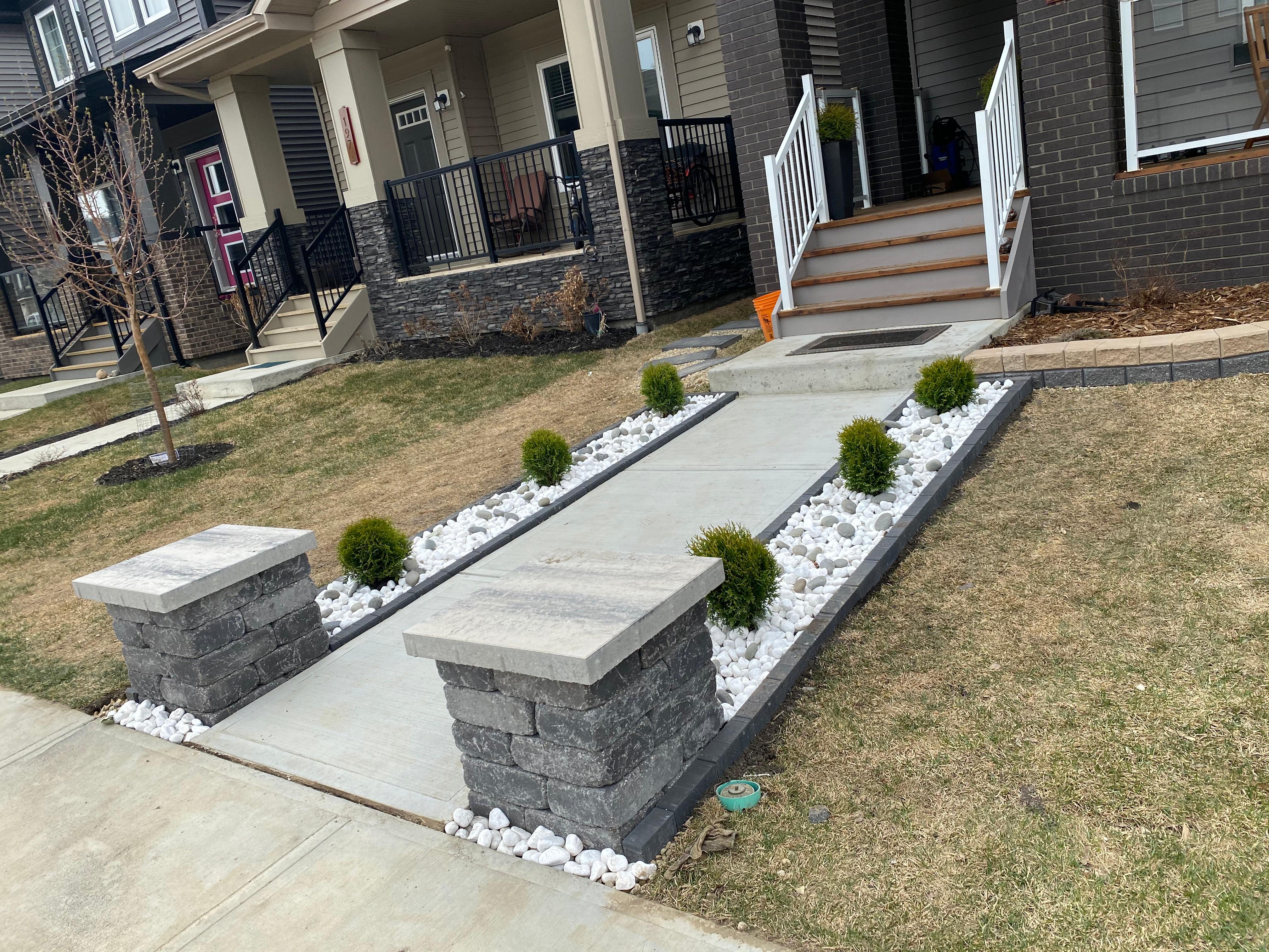 ALA Landscaping completed front yard with stone retaining wall pillars and white rock landscaping